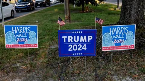 Competing Trump/Harris campaign signs on a lawn in Savannah, Georgia