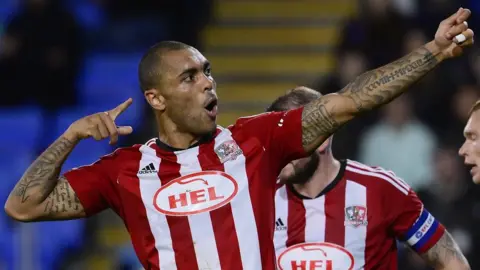 Exeter's Josh Magennis delivers an archery-themed celebration to mark his goal at Shrewsbury